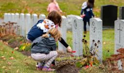 Girl Guide No Stone Left Alone - Guider placing a poppy on a headstone