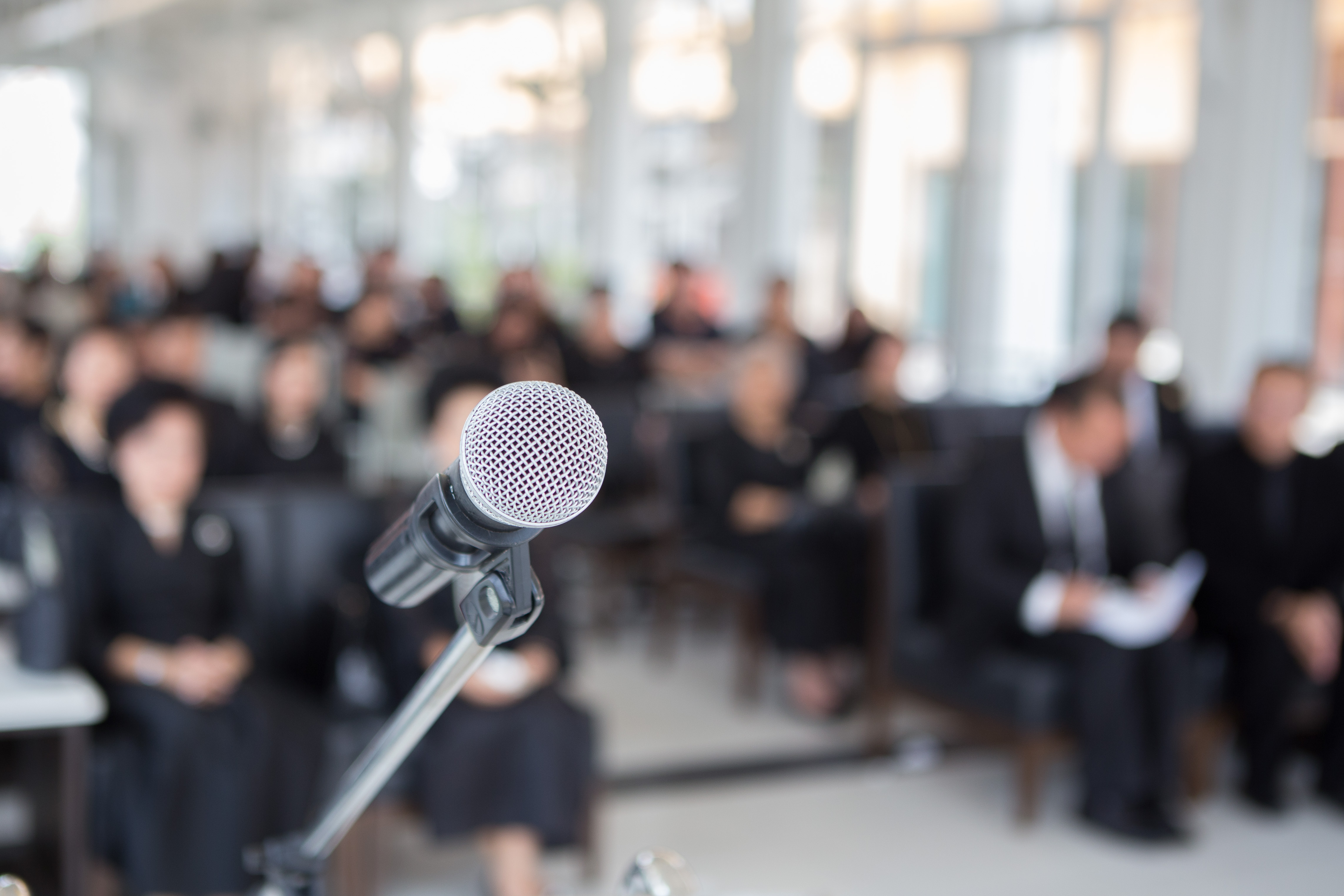 Close-Up Of Microphone Against People Sitting In Church