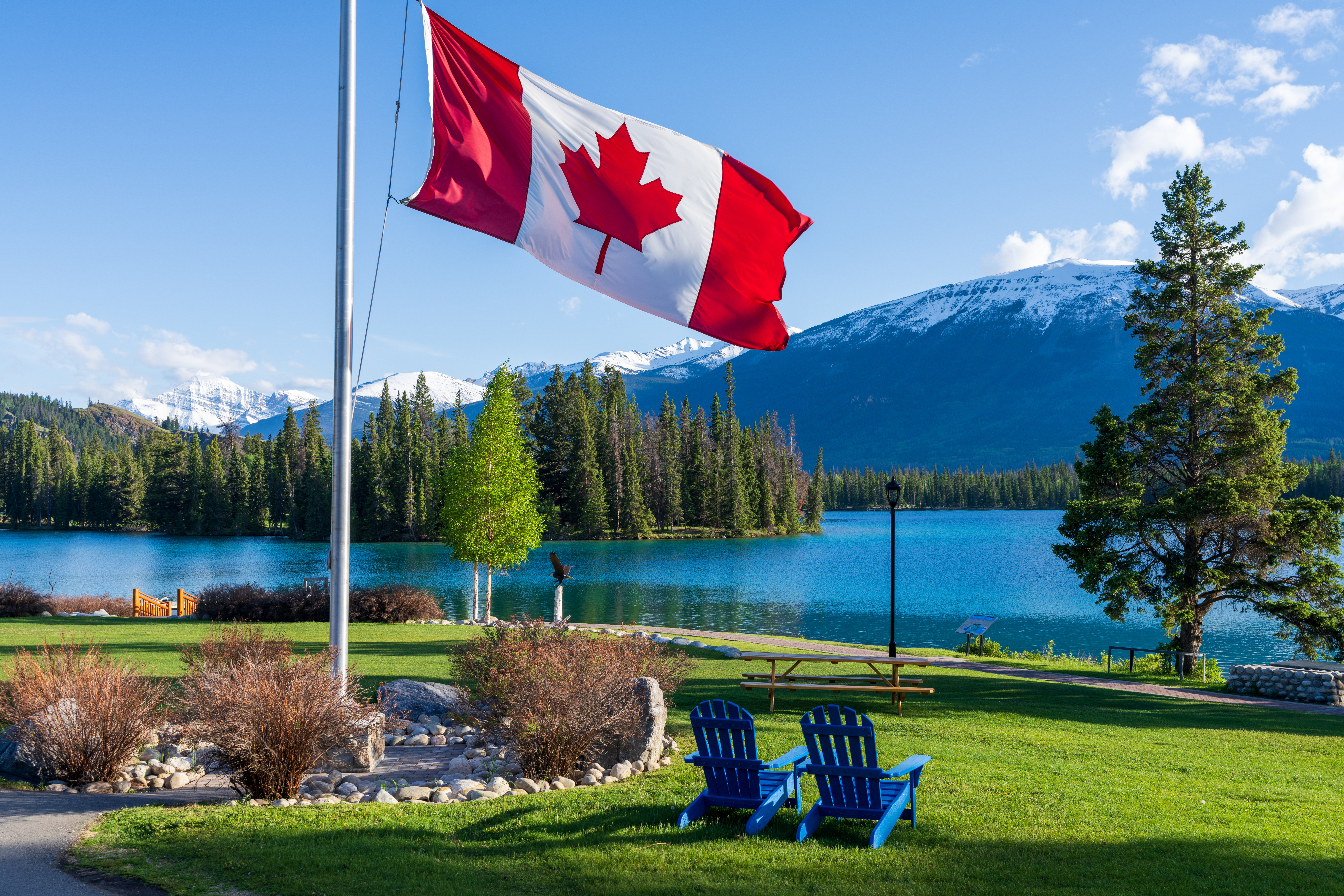 National Flag of Canada with mountain and forest. Jasper National Park summer landscape. Lac Beauvert Trail (Beauvert Lake). stock photo